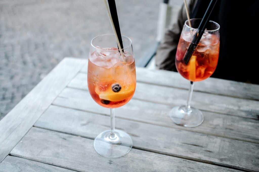 Two colorful cocktails on a wooden desk